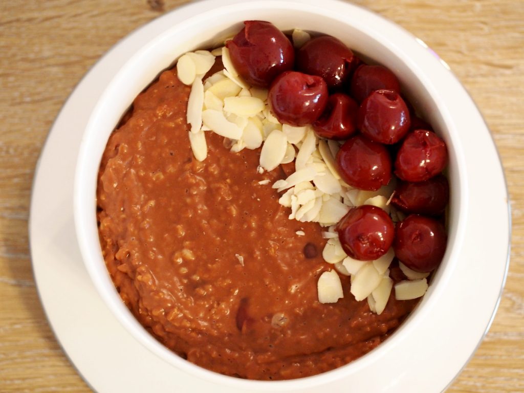Ein Nougatporridge mit Kirschen aus dem Glas und Mandelsplittern