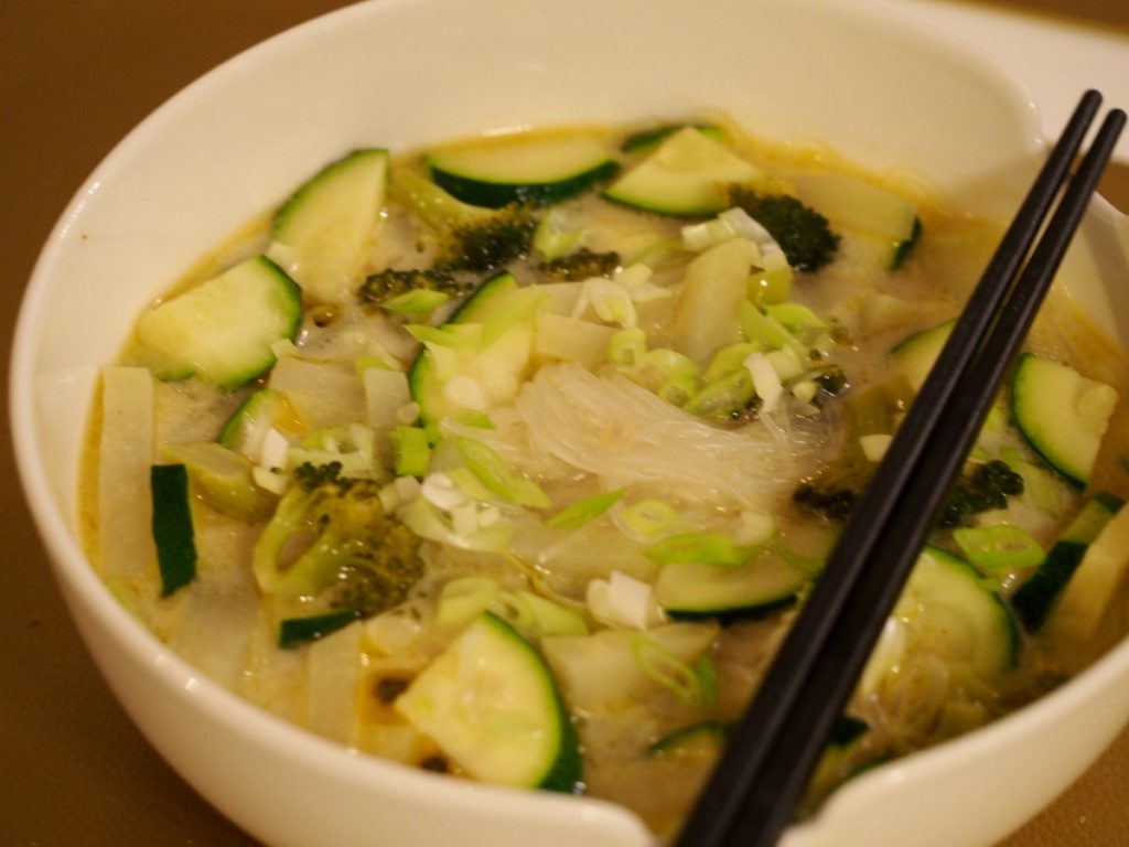 Eine Glasnudelsuppe in einer Schüssel über der zwei Essstäbchen gelegt wurden