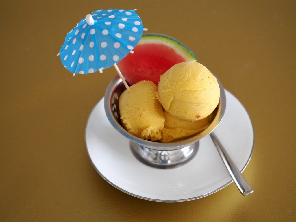 Ein paar Kugeln Mango-Chili Eiscreme in einer Dessertschale