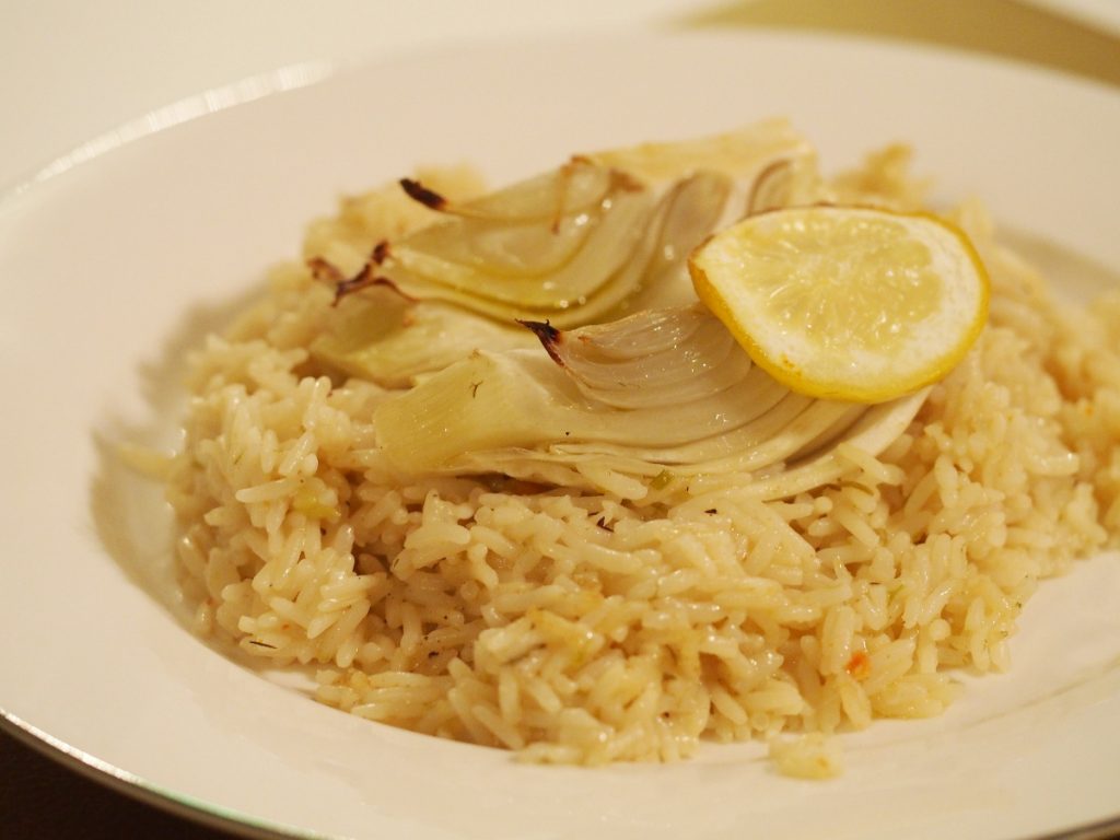Reisauflauf mit Fenchel, dekoriert mit einer Zitronenscheibe