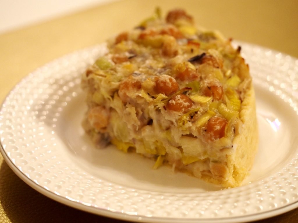 Ein Stück einer veganen Lauch Quiche mit Kichererbsen