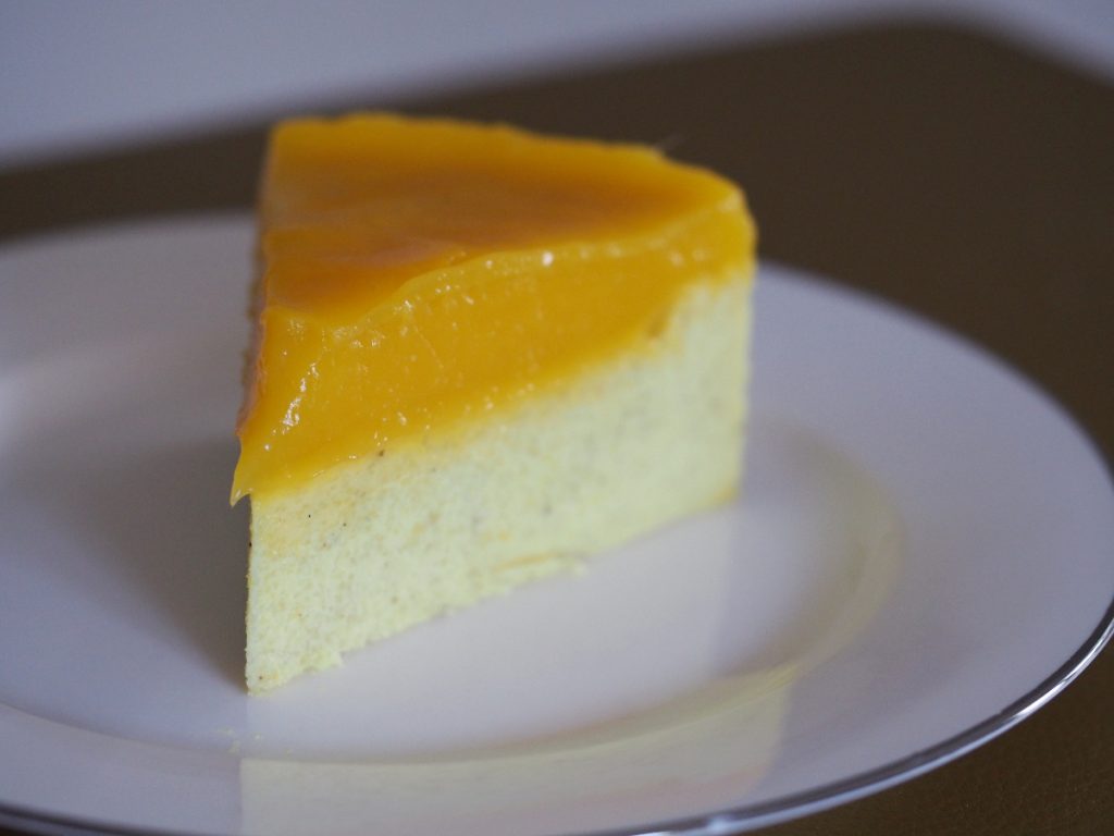 Ein Stück des veganen Grieskuchen mit Mangopudding oben auf