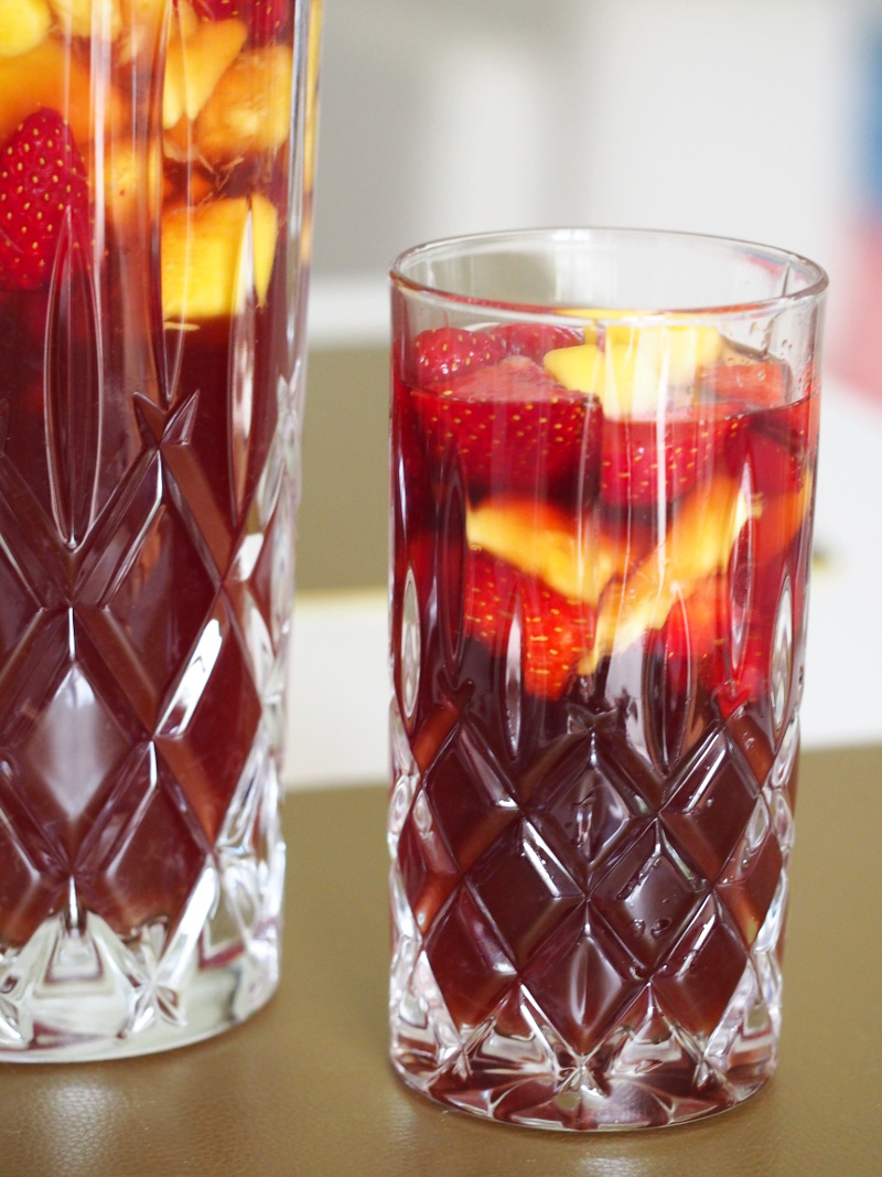 Eine alkoholfreie Mango-Erdbeer Bowle in einem Glas und daneben in einer Karaffe