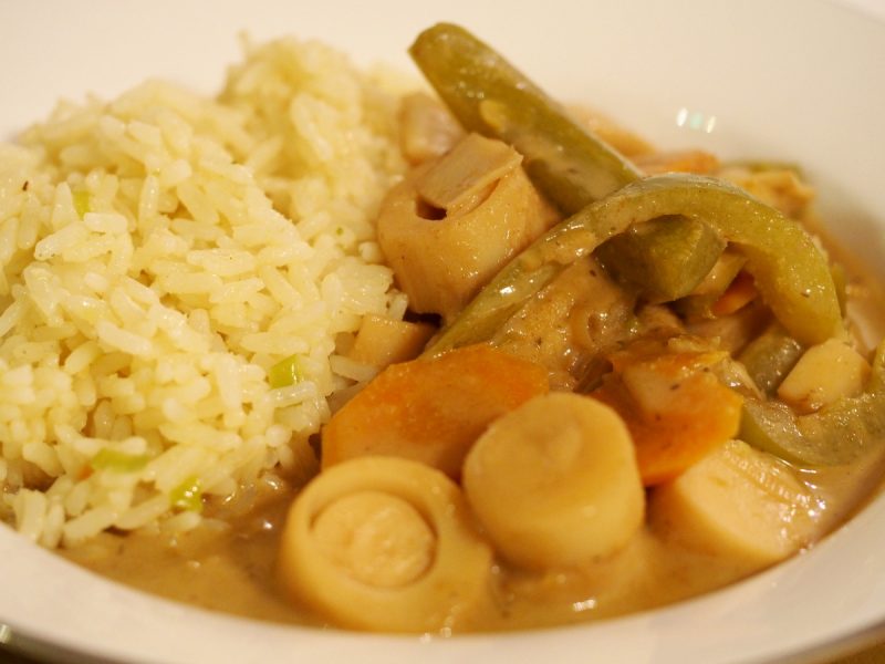 Eine Portion des Curry mit Palmherzen neben etwas Reis.
