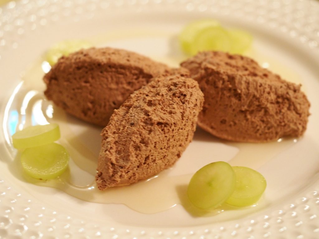 Drei Nocken des veganen Schokomousse auf einem weißen Teller