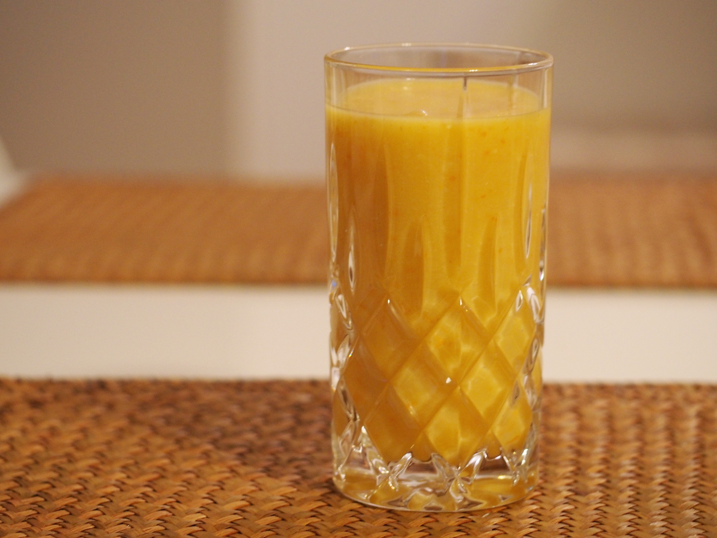 Ein Orangen-Kaki Smoothie in einem Glas