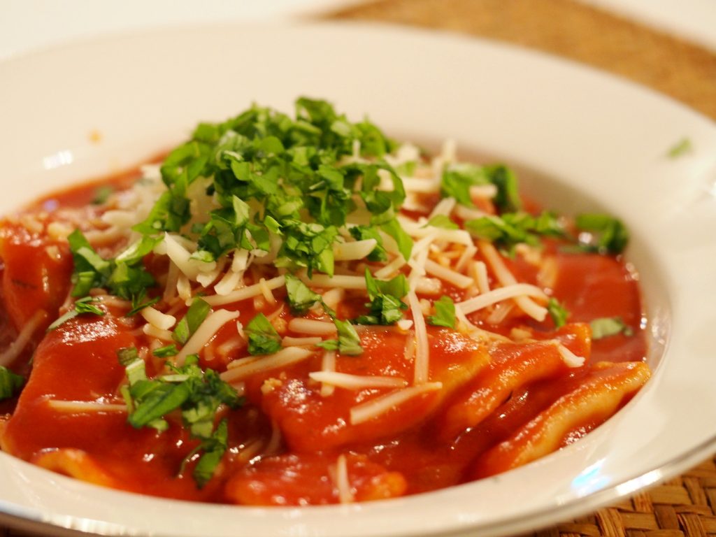 Ravioli in Tomatensauce, dekoriert mit Schnittlauch