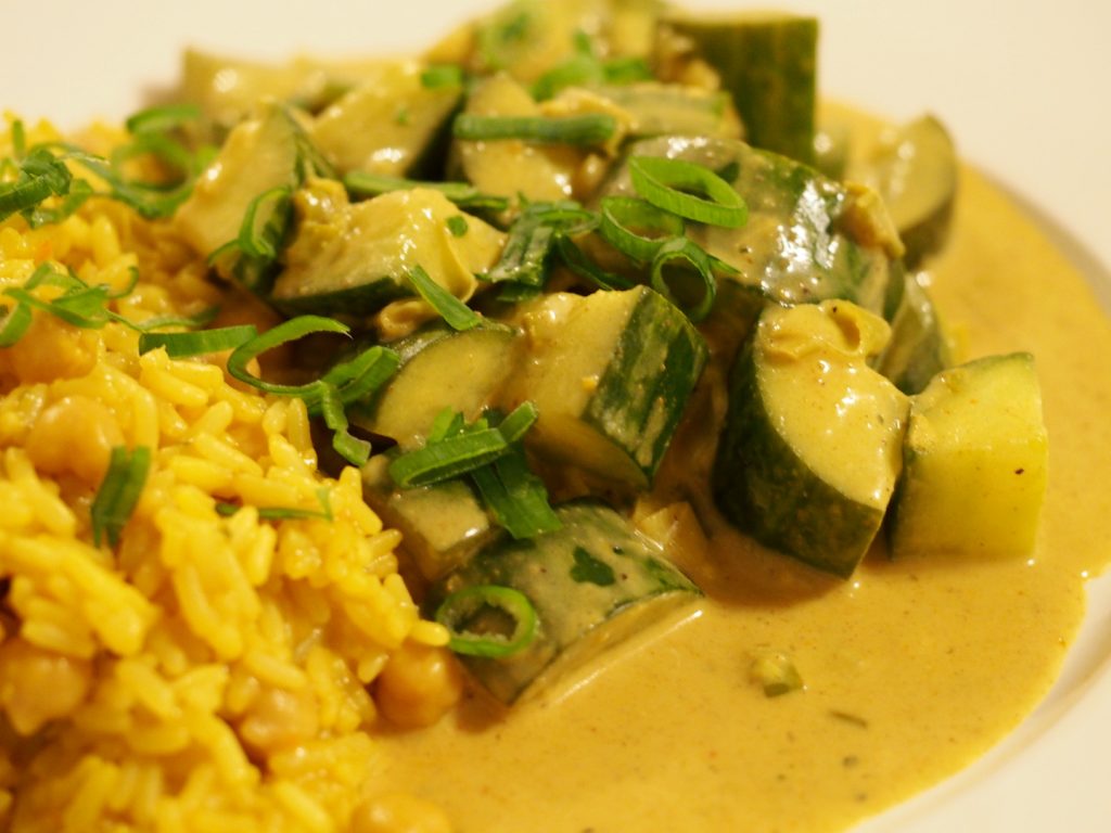 Eine Portion des Gurkencurry mit Reis und viel Sauce auf einem Teller