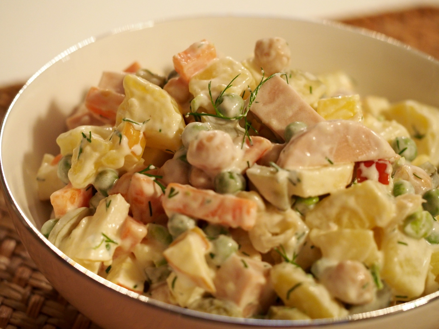 Ein russisch oder slavischer Kartoffelsalat mit Fleischwurst, Karotten und Erbsen
