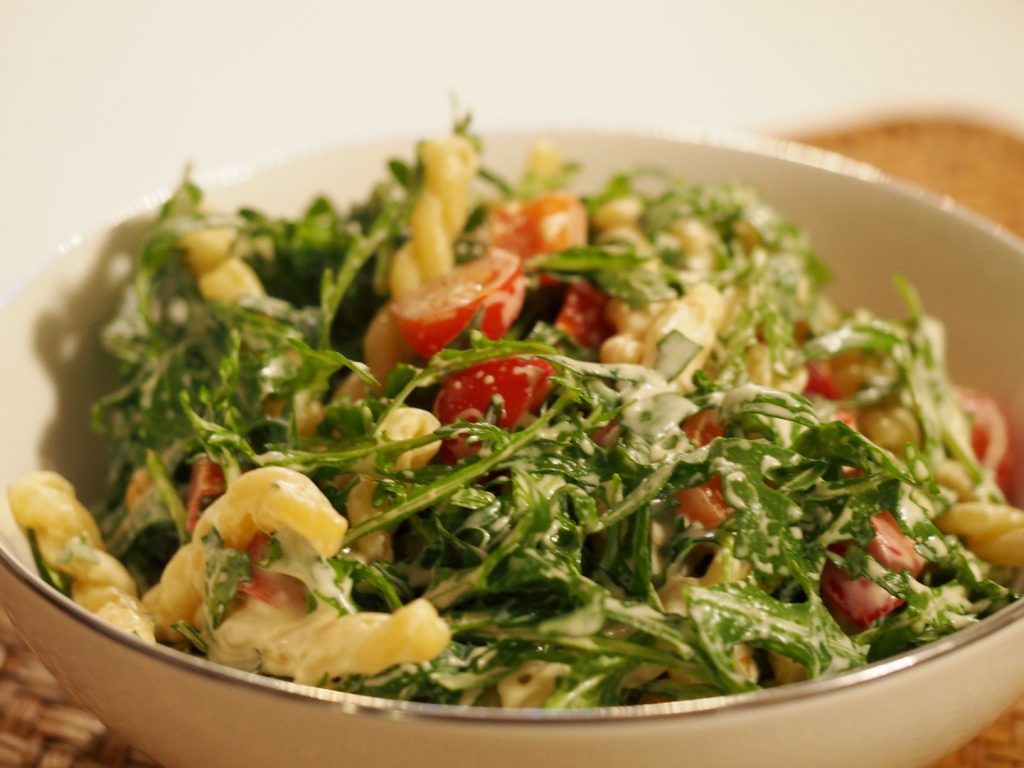 Ein Nudelsalat mit Rucola und Tomaten