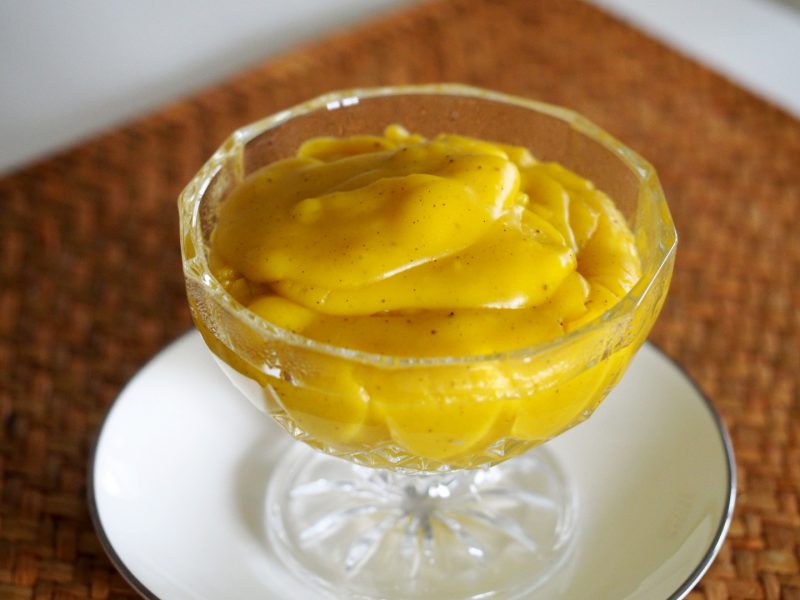 Ein goldgelber Safran Pudding in einer gläsernen Dessertschüssel