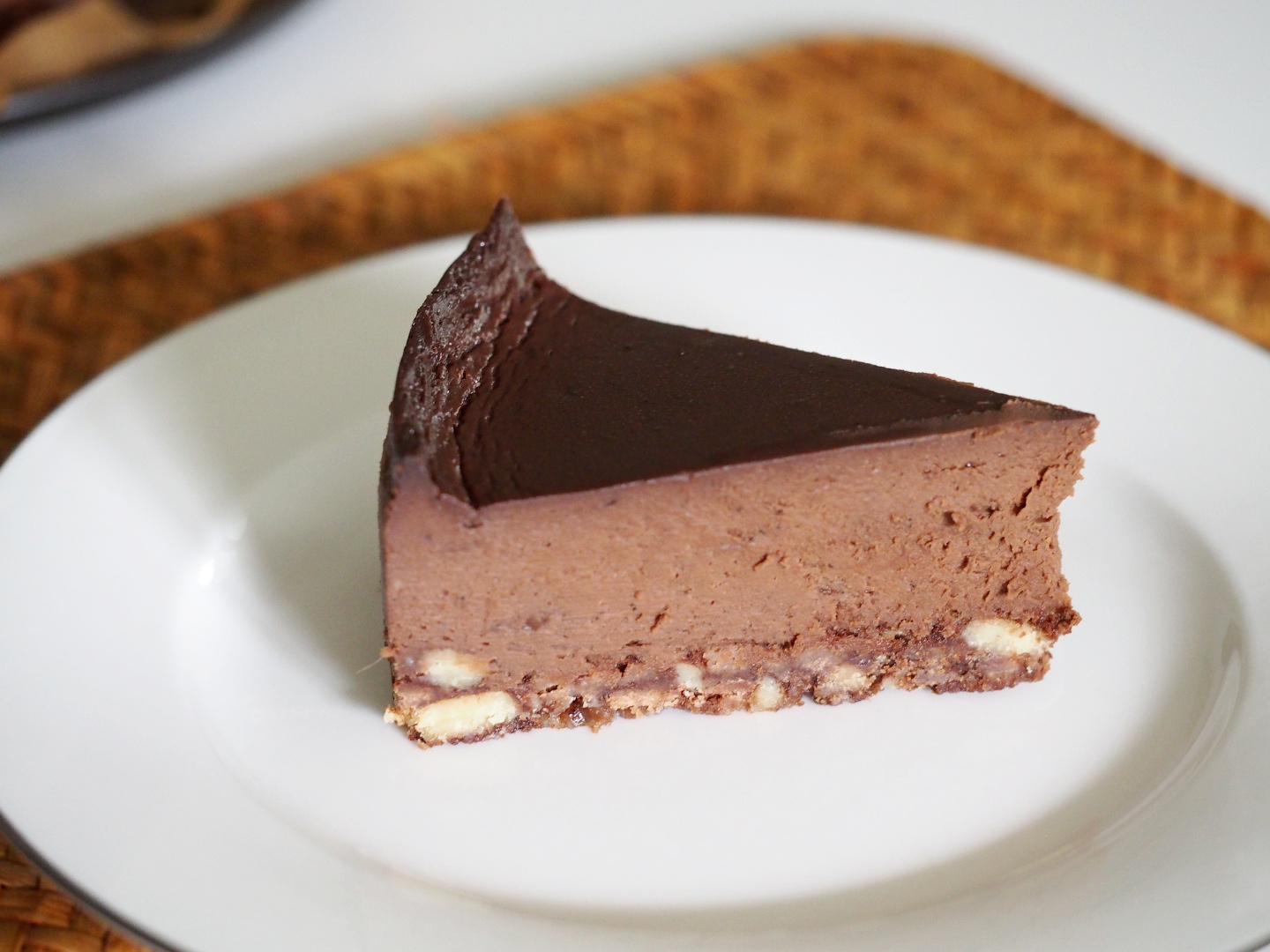 Ein Stück des veganen Schokoladen Cheesecake auf einem Kuchenteller