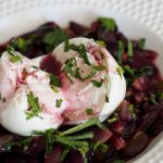 Ein aufgeschnittener Burrata auf marinierten roten Trauben