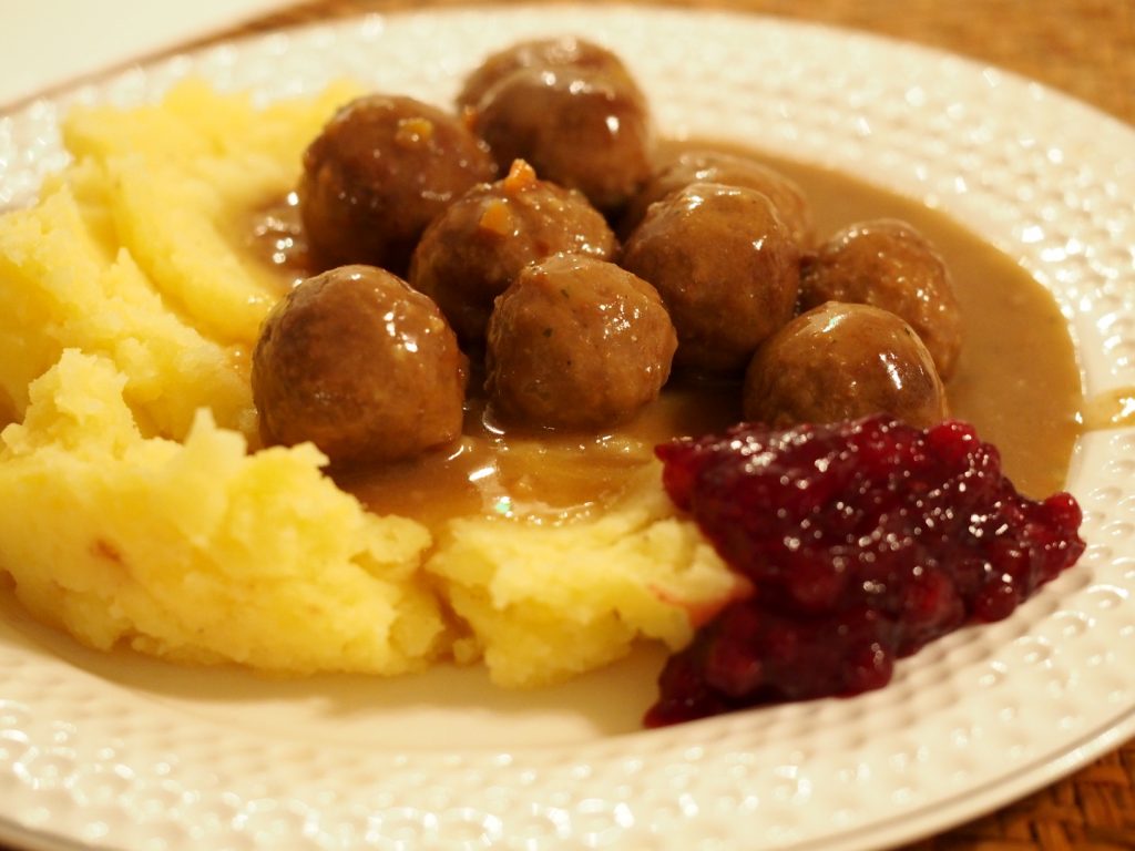 vegane Köttbullar auf einem Teller mit Kartoffelstampf und Preiselbeeren
