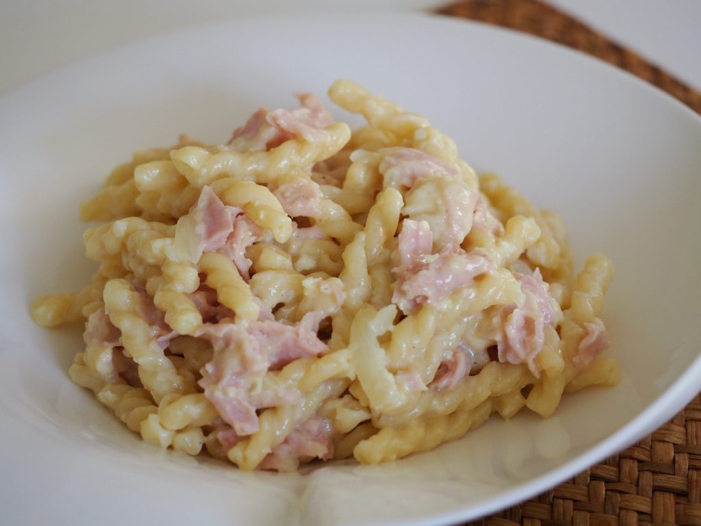 Eine Portion Schinkennudeln auf einem weißen Teller
