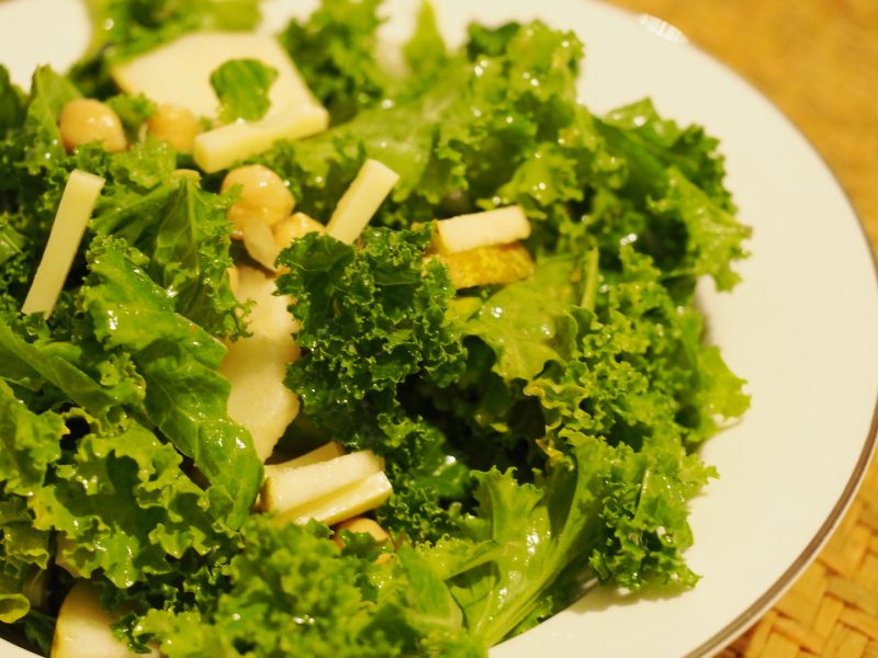 Grünkohlsalat mit Brinen- und Käsestücken auf einem Teller