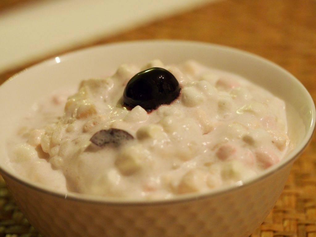 Der Milchreis ähnliche Salat in einer kleinen Schale, getoppt von einer Amarena Kirsche