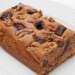 Der angeschnittene Chocolate Chip Kuchen mit eingebackenen Schokoladen- und Walnussstücken