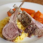 Zwei Stücke des Lammkarree auf Polenta mit Karottengemüse daneben