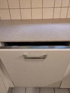 Eine halb geöffnete Spülmaschine mit den Bedienelementen am oberen Rand der innenliegenden Gerätekante