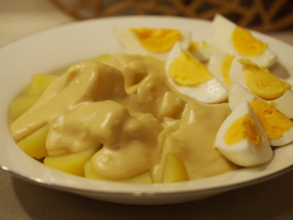 Eine große Portion der gekochten Kartoffeln und in Viertel aufgeschnittenen Eier mit der Senfsauce