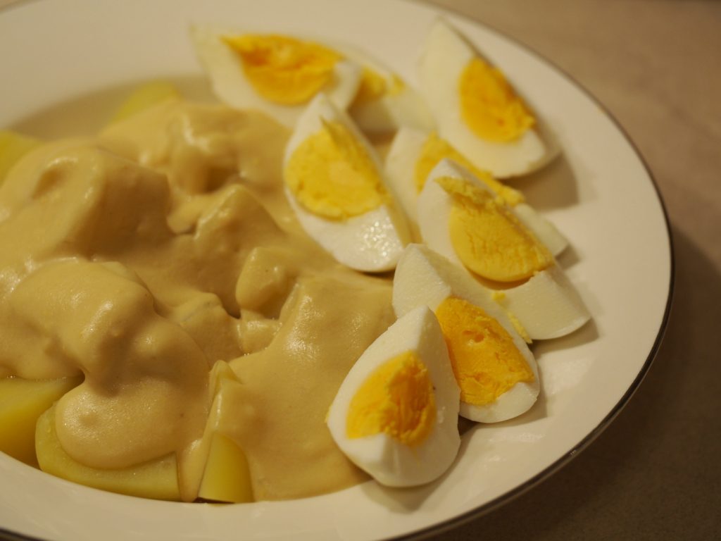 Eine große Portion der gekochten Kartoffeln und in Viertel aufgeschnittenen Eier mit der Senfsauce