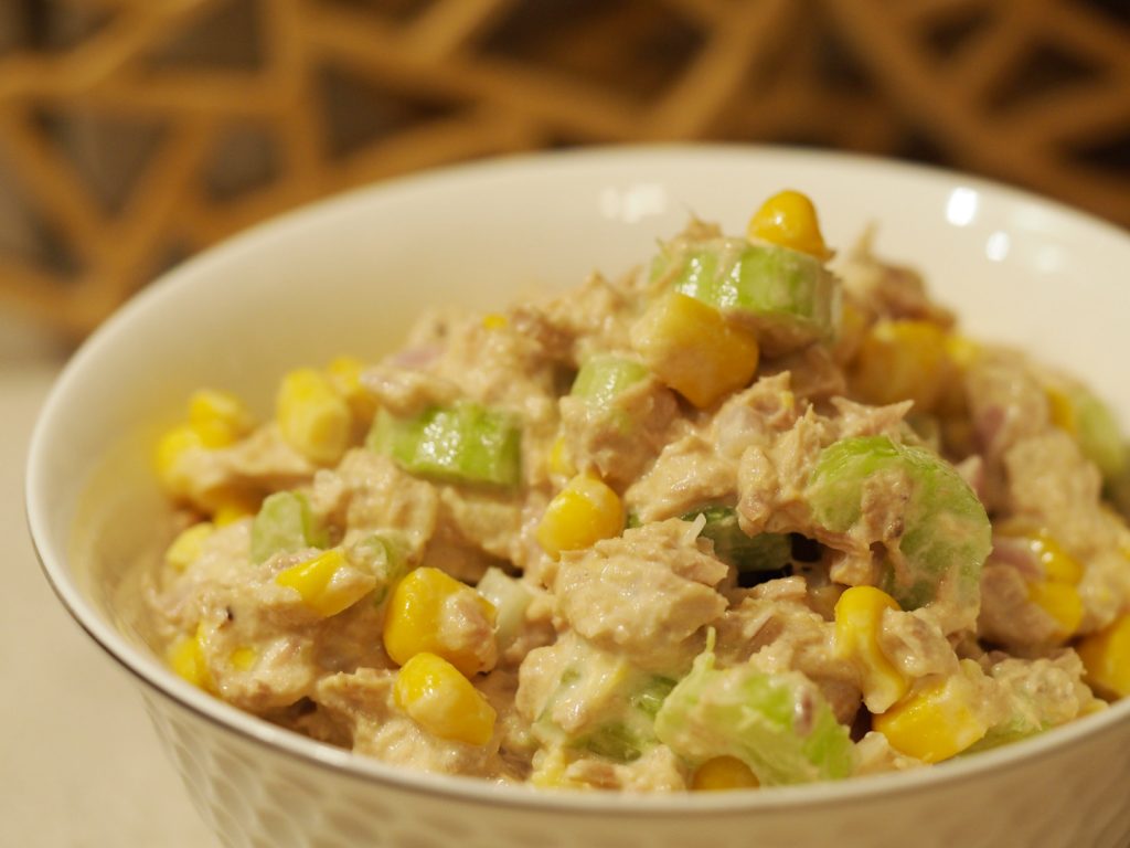 Eine kleine Schüssel mit dem Thunfischsalat mit Zwiebeln, Sellerie und Mais