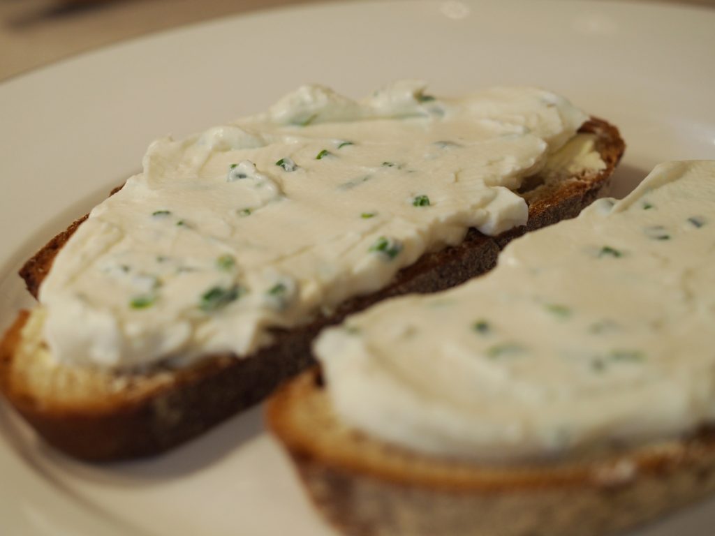 Zwei Brotscheiben bestrichen mit etwas Margarine und dem Schnnittlauchquark