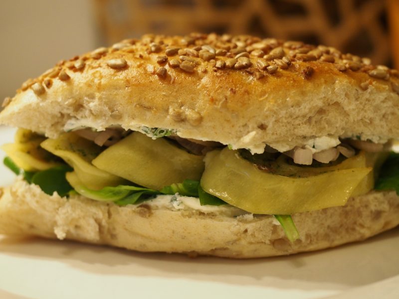 Das fertige Sandwich mit Maultaschen, Schalotten und Feldsalat auf einem Teller