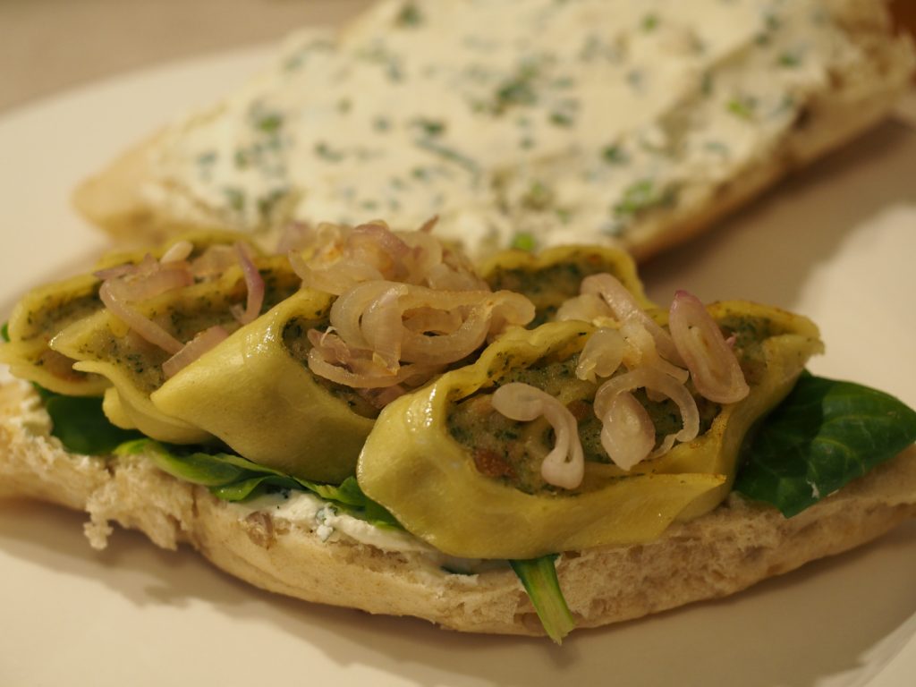 Das noch offene Sandwich, dabei ist eine Seite bereits mit den Maultaschen, den Schalotten und dem Feldsalat belegt.