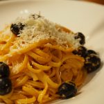 Eine Portion der Pasta mit Pesto und Oliven wurde mit etwas geriebenen Grana Padano bestreut.