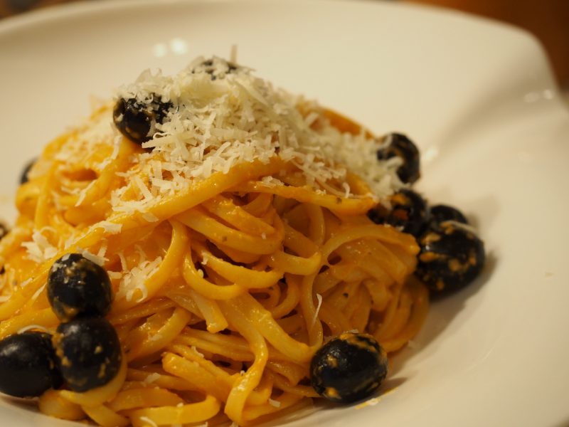 Eine Portion der Pasta mit Pesto und Oliven wurde mit etwas geriebenen Grana Padano bestreut.