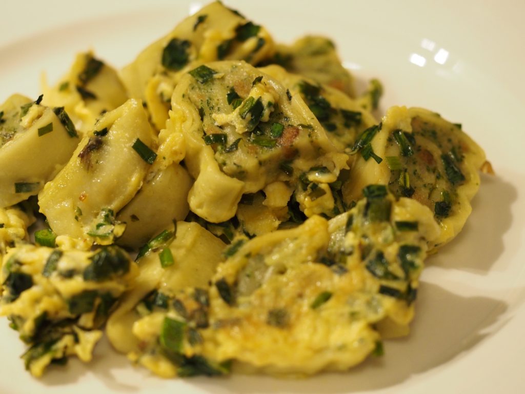 Eine Große Portion der geschmelzten Maultaschen mit Ei und Schnittlauch auf einem Teller.