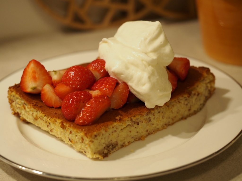Ein Stück des Käsekuchen schwedischer Art mit frischen Erdbeeren und etwas Sahne