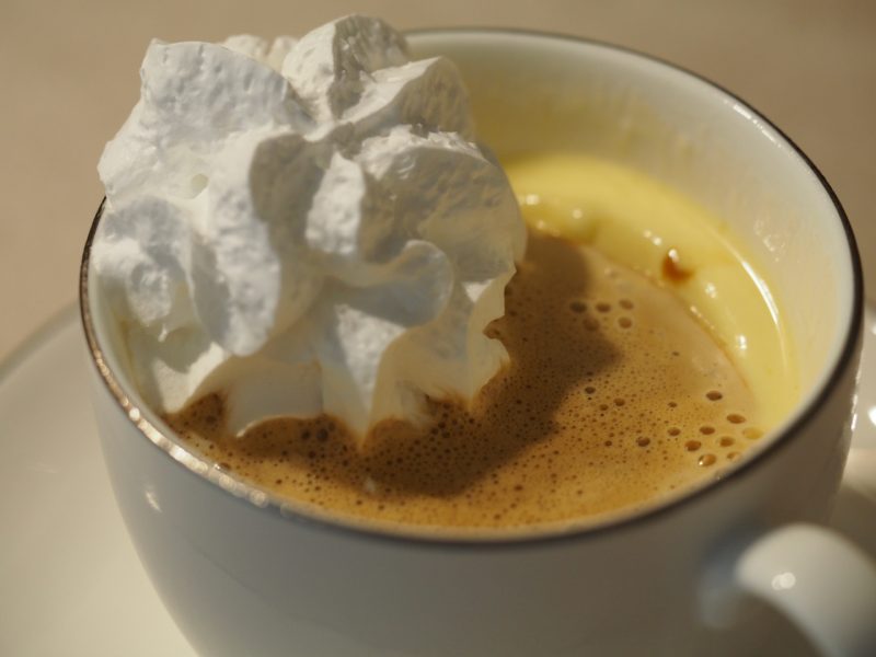 Eine Tasse gefüllt mit Vanilleeis und Espresso, darauf ist noch ein Häubchen vegane Sahne