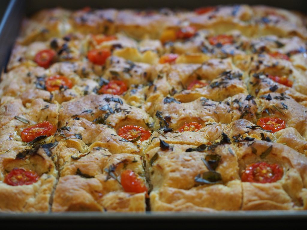 Die Focaccia noch auf dem Backblech, die bereits in einzelne Stücke geschnitten wurde