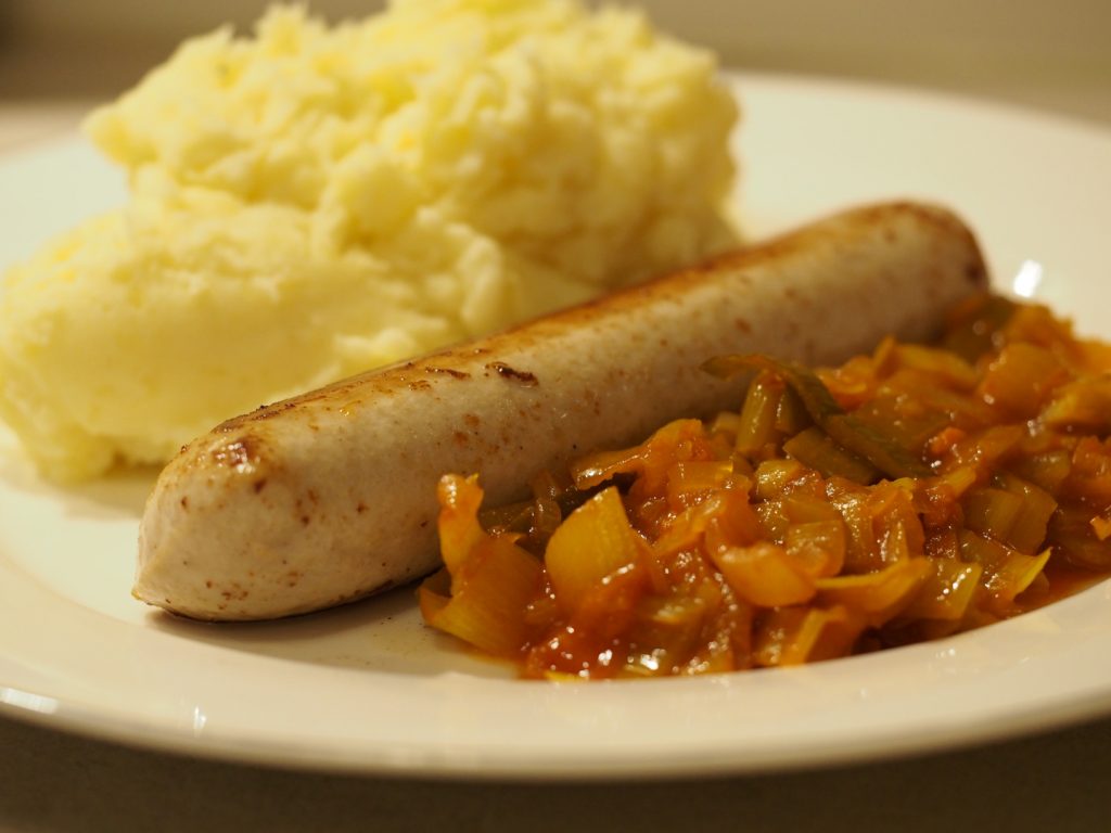 Eine gebratene Oberländer Bratwurst zwischen einem Zwiebel-Lauch Gemüse und etwas Kartoffelstampf