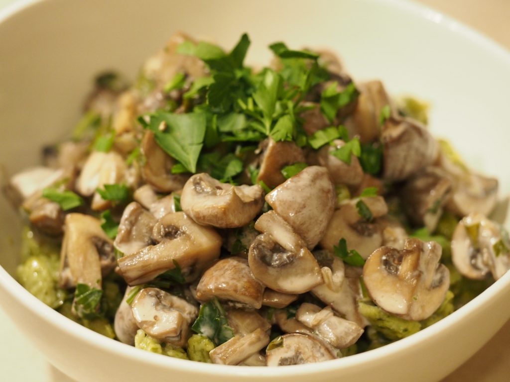 Champignons auf grünlichen Spinat-Spätzle, bestreut mit frischer Petersilie