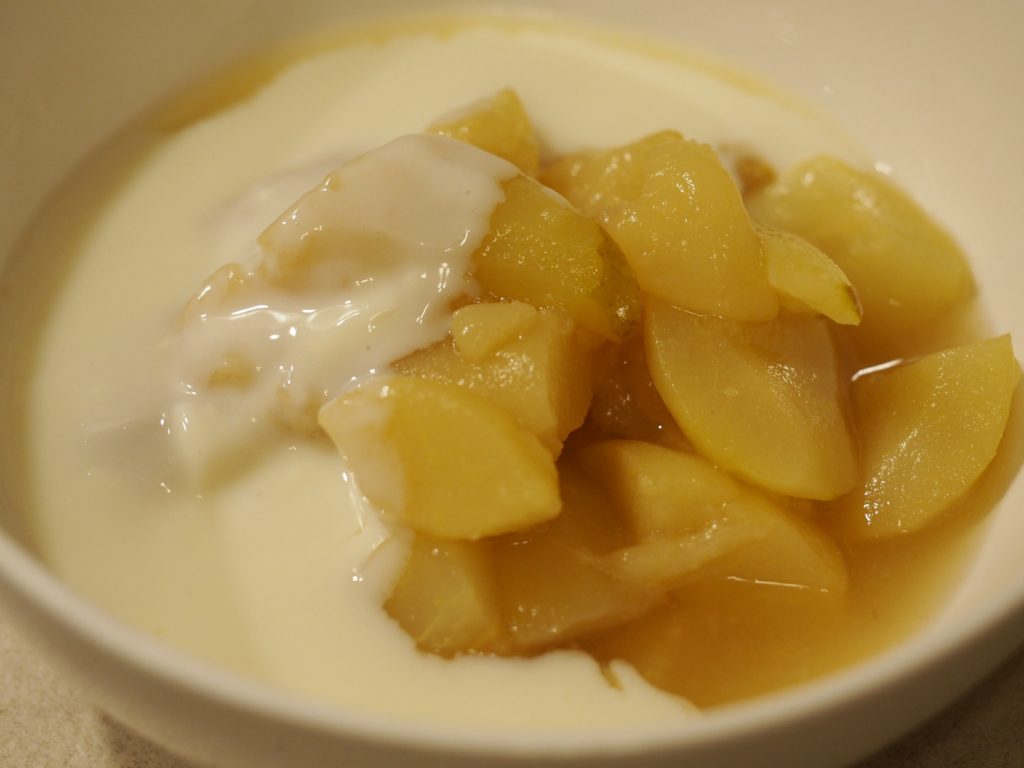 Etwas Birnenkompott mit der feinen Vanillesauce in einer weißen kleinen Schüssel
