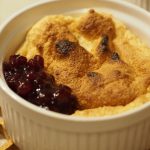 Eine sehr kleine Portion Salzburger Nockerl mit ein paar Löffel Preiselbeeren an der Seite.