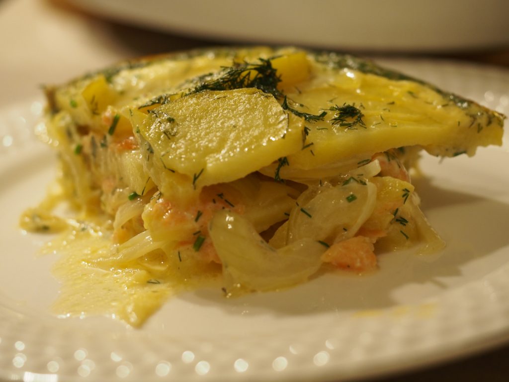 Eine Portion des Kartoffelauflaufs mit Räucherlachs