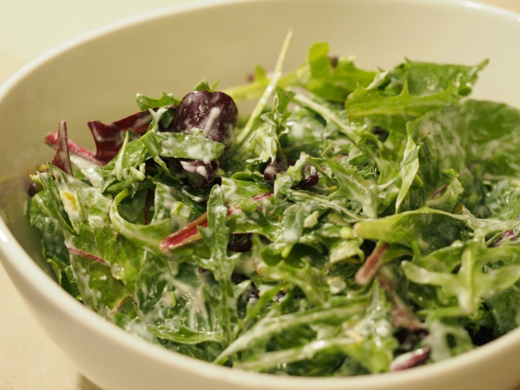 Ein grüner Salat angemacht mit einem Dressing aus Sahne und Zitronensaft
