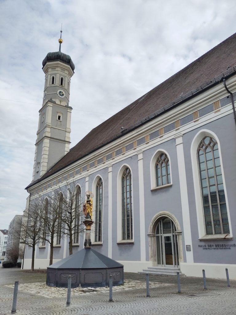Die Dreifaltigkeitskirche - das Haus der Begegnung von der zur Straße gerichteten Längsseite des Gebäudes. Davor steht der Petrusbrunnen.