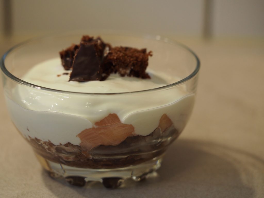 Ein Schichtdessert aus einem Schokokuchen, Rhabarberkompott und griechischem Joghurt