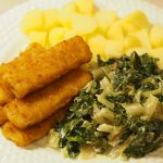 Eine Portion Fischstäbchen mit gekochten Kartoffeln und einem Mangold-Rahmgemüse