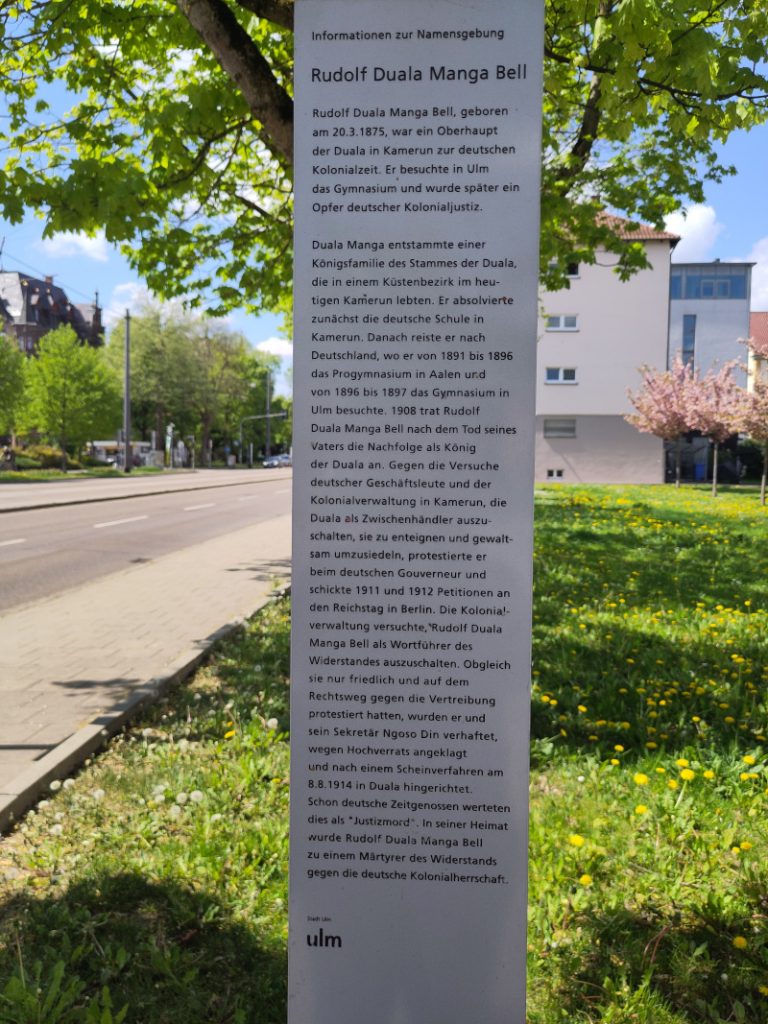 Die Informationstafel zum Rudolf-Duala-Manga-Bell Platz und der Person Rudolf Manga Bell aus dem Stamm der Duala.