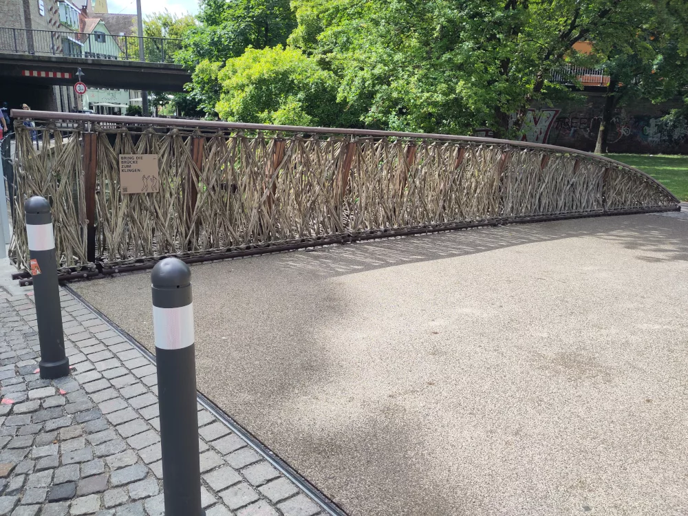Der Weg auf der Brücke mit dem sichtbaren Bodenbelag aus einem Verbundwerkstoff mit Flachsfasern.