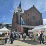 Der Töpfermarkt auf dem Petrusplatz. Über den Ständen ragt die Kirche empor