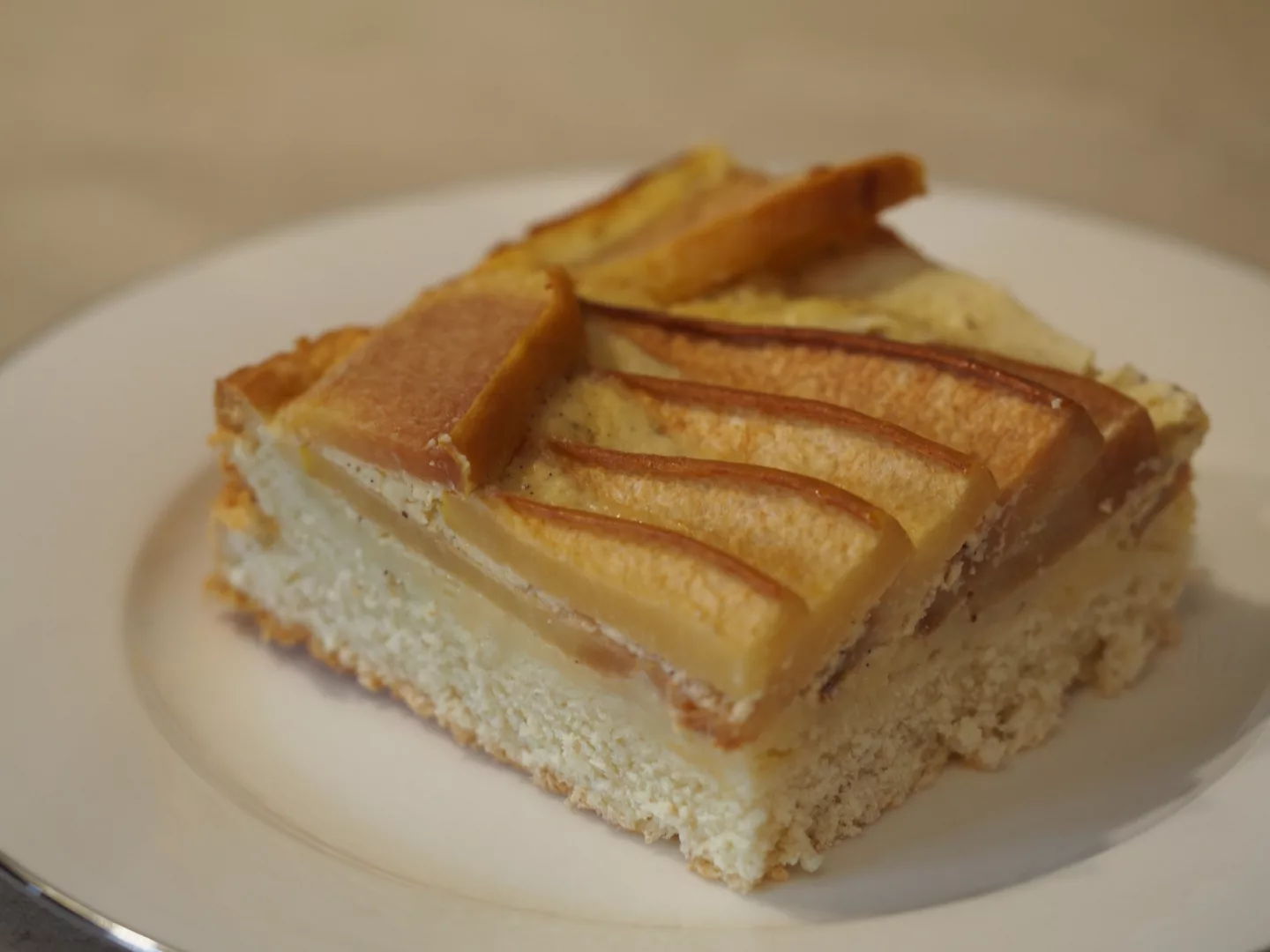 Ein Blechkuchen mit Quitten und einer Creme fraiche Schicht.
