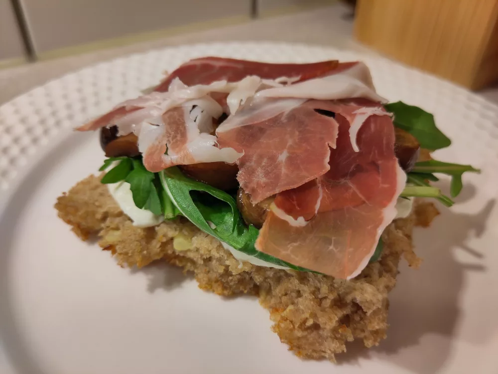 Die untere Hälfte des Focaccia wurde mit Mozzarella, Rucola, Champignons und Prosciutto belegt.